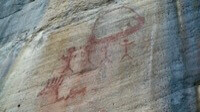 Dessins au trait en rouge sur une paroi rocheuse.